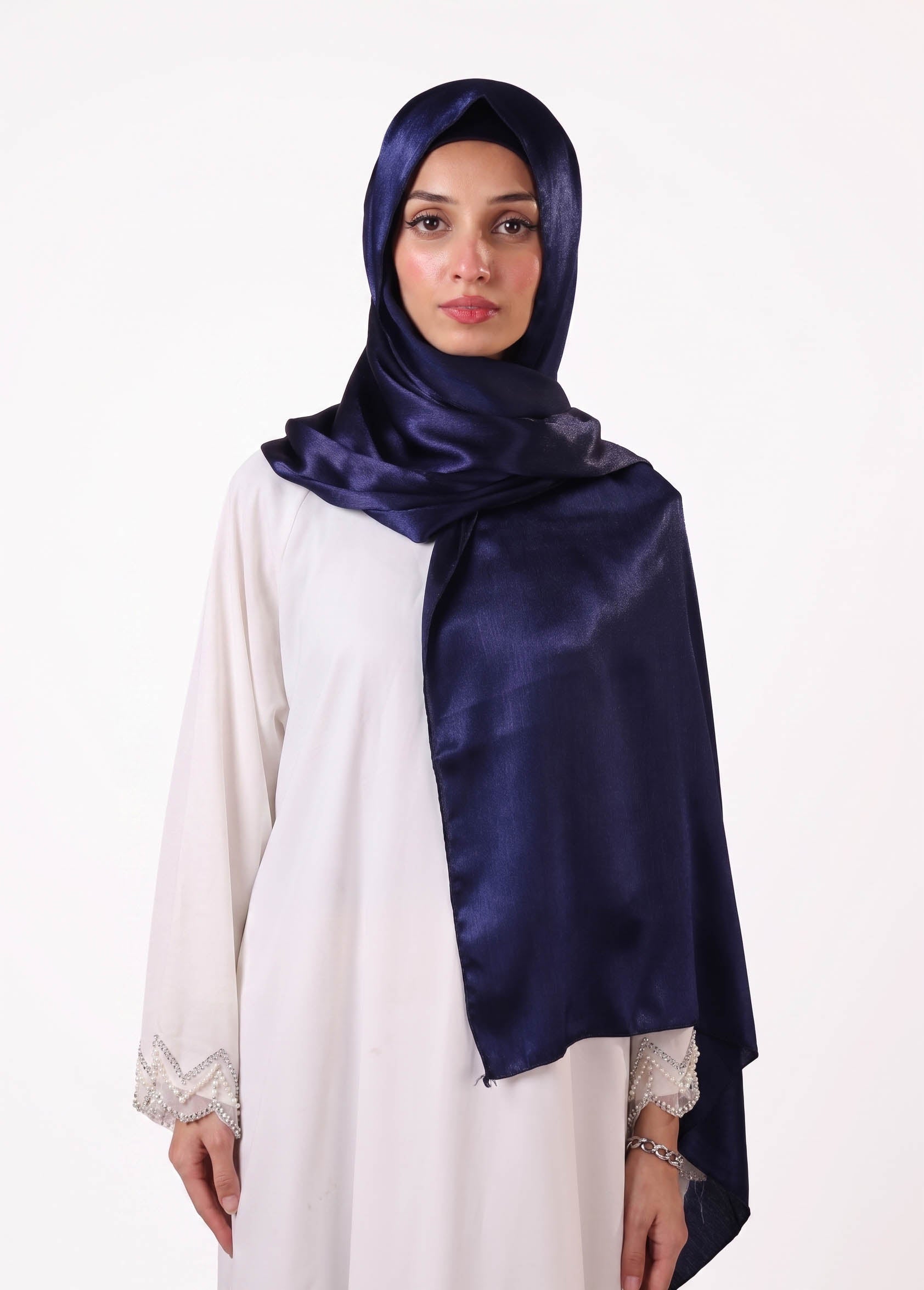 Woman wearing a navy hijab and white dress 